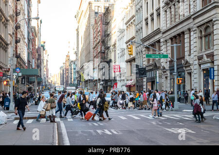 NEW YORK CITY, ca. 2018: Besetzt Massen von Menschen auf der Kreuzung von Broadway und Spring Street zu Fuß in das Viertel SoHo von Manhattan, NYC Stockfoto