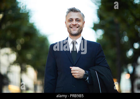 Lächelnd erfolgreicher Geschäftsmann in formale an Sie, während Sie Walking Street Stockfoto