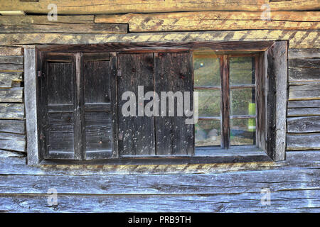 Fenster mit Fensterläden auf alten Holzhaus log Stockfoto