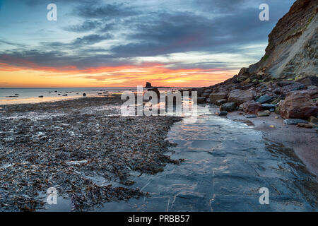 Atemberaubenden Sonnenaufgang über dem felsigen Strand bei Saltwick Bucht auf der Yorkshire Küste in der Nähe von Whitby Stockfoto