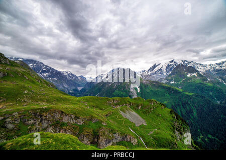 Malerischer Blick auf die schöne Landschaft der Schweizer Alpen. Frischen, grünen Wiesen und schneebedeckten Gipfeln im Hintergrund im Frühling, die Schweiz begrenzt. Stockfoto
