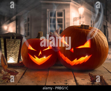 Spooky Halloween Kürbisse auf Holzplanken in der Nacht. Stockfoto