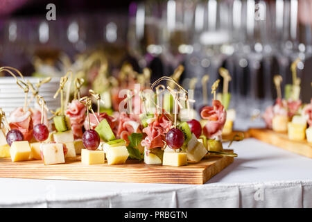 Leichte Snacks in einer Platte auf einem Buffet. Sortiert mini Canapes, Köstlichkeiten und Snacks, Essen im Restaurant an der Veranstaltung. Einen Galaempfang. Dekoriert köstliche Tabelle für eine Partei Goodies. Stockfoto