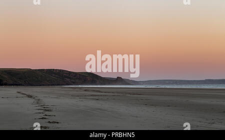 Warmen, klaren orange Sonnenuntergang Himmel über Sandstrand in Newgale, Pembrokeshire, Großbritannien Stockfoto