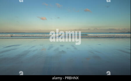 Sonnenaufgang über nasser Sandstrand reflektierende sunrise Licht in Newgale, Pembrokeshire, Großbritannien Stockfoto