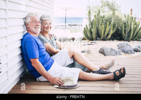 Gerne älteres Paar lachend auf dem Boden auf holzbohlen an einem Sommertag Stockfoto