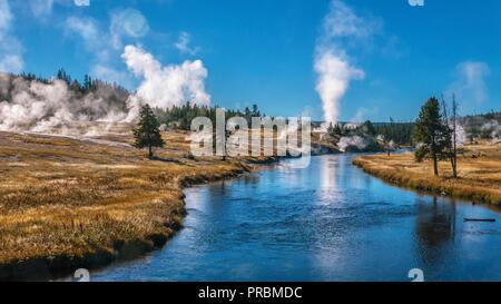 Blick auf den Firehole River fließt durch Yellowstone's Upper Geyser Basin, Teil der meisten aktiven geysir Feld in der Welt. Old Faithful kann se werden Stockfoto