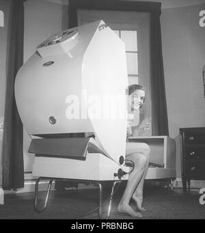 Schönheitspflege in den 1950er Jahren. Eine junge Frau sitzt in einer Maschine namens Infra Thermo. Eine Behandlung in der Maschine lindert Schmerzen durch Hitzewellen. Schweden 1951. Foto Kristoffersson Ref. BB81-9 Stockfoto