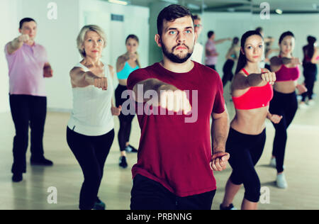 Glücklich lächelnde Schlank athletische Frauen und Männer tanzen Streifen aus Kunststoff in der Klasse Stockfoto