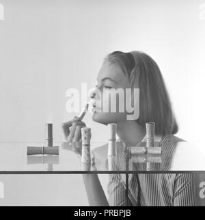 Make-up in den 1950er Jahren. Eine junge Frau mit Lippenstift. Schweden 1957 Stockfoto