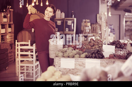 Junge Spanische Frau Wahl Artischocken in Farm Food Store Stockfoto