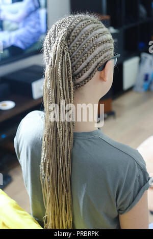 Viel dünne afrikanische Zöpfe mit künstlichem Material, blonde Close-up auf hellem Hintergrund, Beauty Studio Stockfoto