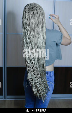 Viel dünne afrikanische Zöpfe mit künstlichem Material, blonde Close-up auf hellem Hintergrund, Beauty Studio Stockfoto