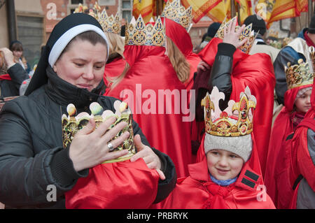 Nonne Kinder helfen mit ihrem Papier Kronen vor Kavalkade der Heiligen Drei Könige, Heilige Drei Könige Urlaub Prozession, Krakau, Polen Stockfoto