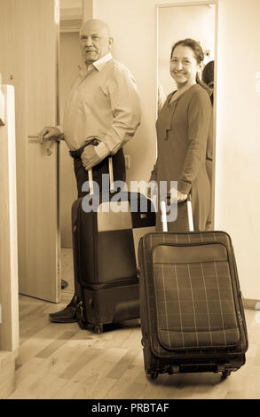 ältere Touristen mit Gepäck in der Nähe der Tür in Haus Stockfoto