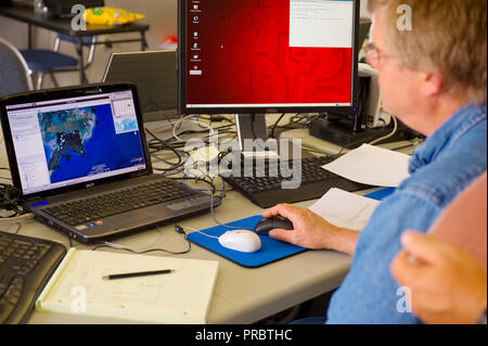 EPA-Mitarbeiter oder Auftragnehmer, die Aspekt Team Leader Punkte die Bemusterung Zielgebiete während der Mission briefing. Stockfoto