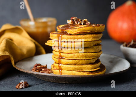 Kürbis Pfannkuchen mit Karamellsauce und Pekannuss, schwarz konkreten Hintergrund. Detailansicht, selektiver Fokus Stockfoto
