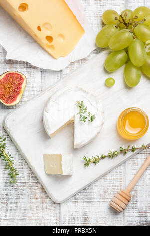 Brie oder Camembert Käse serviert mit Früchten und Honig auf weißem Käseplatte. Ansicht von oben Stockfoto