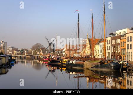 Niederlande, Leiden - Blick auf die Altstadt mit der Molen De Valk - Windmühle mit einem Wasserrad und 1900s-style Wohnräume. Leiden kommunalen Wind Stockfoto