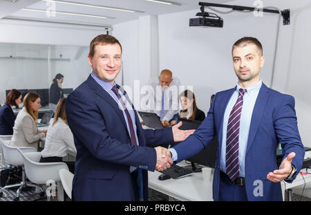 Zwei Geschäftsleute zufrieden die Hände schütteln, während Sie schlichten Treffen, die Vereinbarung Stockfoto