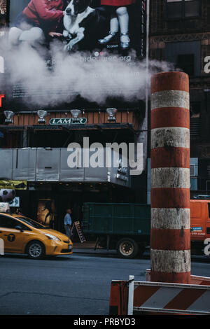 New York, USA - 30. MAI 2018: Gelbe Taxi fährt vorbei an der Dampf Dampf orange und weiß. Gelbe Taxis werden weltweit als Symbole von t erkannt Stockfoto