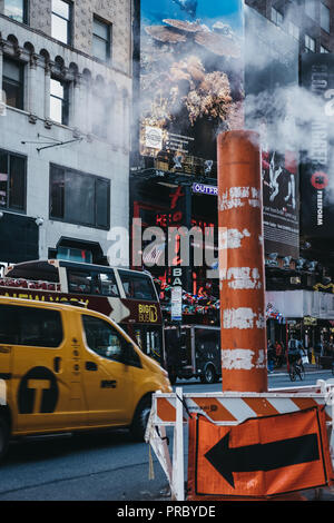 New York, USA - 30. MAI 2018: Gelbe Taxi fährt vorbei an der Dampf Dampf orange und weiß. Gelbe Taxis werden weltweit als Symbole von t erkannt Stockfoto