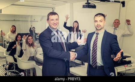 Zwei Erwachsener zufriedene Geschäftsleute die Hände schütteln, während Sie schlichten Treffen, die Vereinbarung Stockfoto