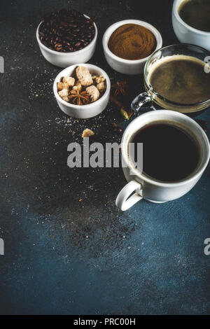 Drei Kaffeetassen, Bohnen, gemahlenen Kaffee und braunem Zucker. Dunkelblauem Hintergrund der Ansicht von oben Platz für Ihren Text Stockfoto