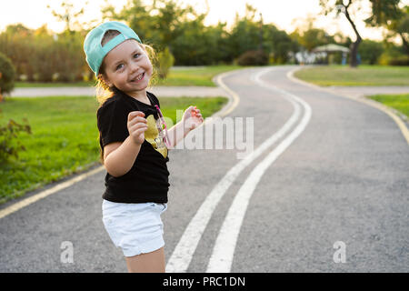 Fashion kid Konzept - Porträt der elegante kleine süße Mädchen Kind trägt eine Kappe im Freien in der Stadt. Stockfoto