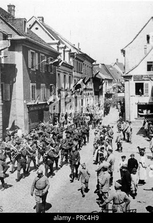 Memorial Day, 1918 - amerikanische Soldaten Memorial Day im Elsass, 30. Mai 1918 feiern. In Masevaux, der provisorisch Hauptstadt des elsässischen Gebiet zurückerobert, die amerikanischen Truppen durch ihre Band unter der Leitung zogen durch die Straßen. In der Kontingent hinter der Band sind eine Delegation der Amerikanischen und der Französischen Offiziere und prominente Bürger Stockfoto