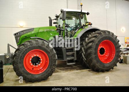 Zusammengesetztes Bild eines modernen grünen landwirtschaftlichen generischen Traktors mit roten Rädern, innen auf weißem Hintergrund Stockfoto