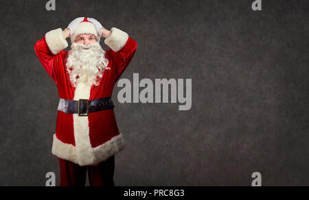 Santa Claus hält seinen Kopf in seinen Händen. Stockfoto