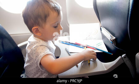 Portrait von Toddler boy Holding Bleistifte in Flugzeug fliegen Stockfoto