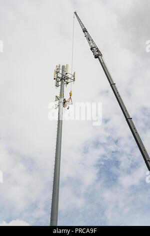 Zelle Turm reparieren oder neu mit einem großen Kran in Montgomery Alabama, USA Installation von 5 G Telekommunikationsnetzes. Stockfoto