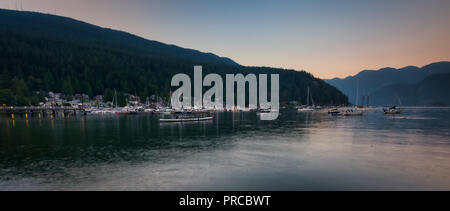 Deep Cove sand Strand gut zum Schwimmen, die alle entlang des Wassers im Dorf gepflastert ist Weg mit der Deep Cove Pier und die Marine in der Mitte Stockfoto