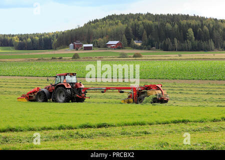 Salo, Finnland - 23 September, 2018: Bauer schneidet das Heu, das auf Ackerland mit NOVACAT T gezogene Scheibenmäher von Case IH CS120 Traktor an einem schönen Tag gezogen. Stockfoto