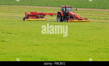 Salo, Finnland - 23 September, 2018: Bauer schneidet das Heu, das auf Ackerland mit NOVACAT T gezogene Scheibenmäher von Case IH CS120 Traktor an einem schönen Tag gezogen. Stockfoto