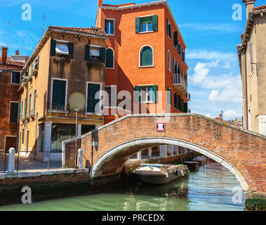 Venezianischen Kanal zwischen alten Gebäuden und kleine Ziegel Fußgängerbrücke im Vordergrund, Italien. Stockfoto