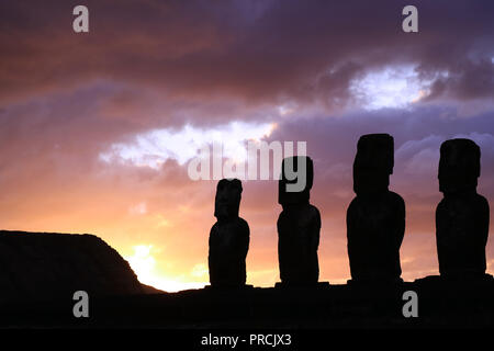 Atemberaubende Purple Sunrise bewölkter Himmel über der Silhouette des riesigen Moai Statuen von Ahu Tongariki Archäologische Stätte, Easter Island, Chile Stockfoto