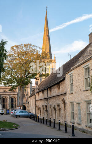 Armenhäuser und St. Johannes der Täufer Kirche in den späten Herbst Nachmittag Sonne. Burford, Cotswolds, Oxfordshire, England Stockfoto