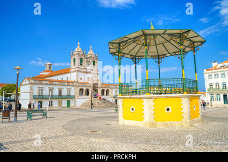 Die Ansicht der Nossa Senhora da nazare Kirche auf dem Marktplatz der kleinen Stadt Nazare. Portugal Stockfoto