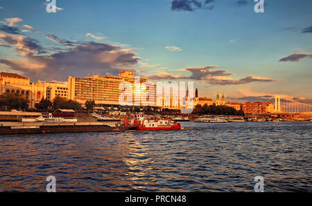 Blick auf die Pest Embankment und Elizabeth Bridge von der Seite der Donau bei Sonnenuntergang. Stockfoto