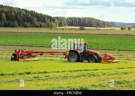 Salo, Finnland - 23 September, 2018: Bauer schneidet das Heu, das auf Ackerland mit NOVACAT T gezogene Scheibenmäher von Case IH CS120 Traktor an einem schönen Tag gezogen. Stockfoto