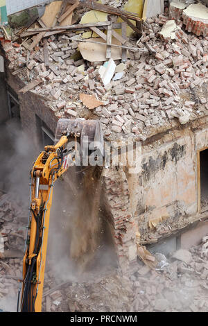 Crushing brick wall, Gebäudeabbruch mit einem Hydraulikbagger, Ansicht von oben. Stockfoto