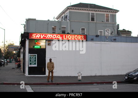 Ein Mann steht vor einem spirituosenladen am 14. und Peralta Straßen in West Oakland. Der Store ist im Film es tut uns Leid, Sie stören. Stockfoto