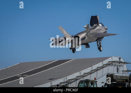 Royal Navy Cmdr. Nathan Gray, Test Pilot mit der F-35 integrierten Test Kraft am NAS Patuxent River, Maryland, macht die erste F-35 B Blitz II Jet von HMS Queen Elizabeth, Ende September 2018. Zwei F-35B Blitz II Kampfjets haben erfolgreich an Bord der HMS Queen Elizabeth landete zum ersten Mal für die Erste Klasse Flug Studien (Fixed-wing), legt den Grundstein für die nächsten 50 Jahre von festen Tragfläche Luftfahrt in Unterstützung des Trägers Schlagkraft in Großbritannien. Gray's Landung wurde von der Royal Air Force Sq gefolgt. Ldr. Andy Edgell, FOCFT (FW) Leitung Test Pilot. Mit freundlicher Genehmigung phot Stockfoto