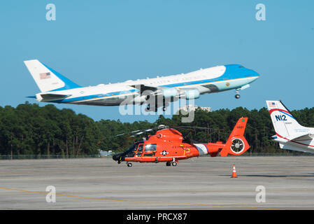 Air Force One nimmt am internationalen Flughafen Myrtle Beach Sept. 19, 2018, während der Küstenwache MH-65 Dolphin Hubschrauber von Air Station Savannah auf dem Asphalt liegt. Präsident Donald Trump besucht die Horry County Emergency Operations Center in Conway, South Carolina, die Küstenwache, die örtliche Polizei und anderen Behörden für ihre Antwort Bemühungen nach dem Hurrikan Florenz danken. (U.S. Coast Guard Foto von Petty Officer 3. Klasse Ryan Dickinson) Stockfoto