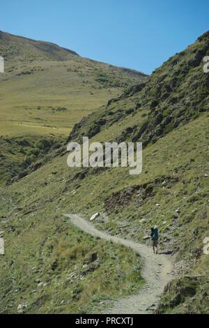 Touristen Trekking in der Nähe der Kirche der Heiligen Dreifaltigkeit Gergeti durch den Fluss Chkheri, unter dem Berg Kazbegi liegt auf einer Höhe von 2170 Metern in den Kaukasus, Georg Stockfoto