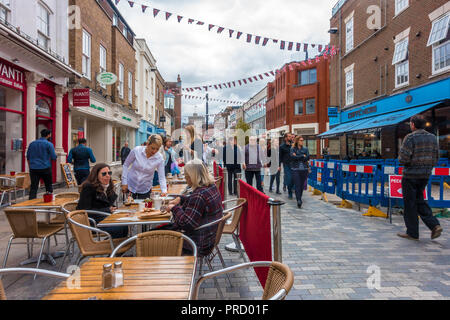 Ein paar Freunde sitzen ein einen Drink ein Cafe in Peascod Street, Windsor, Großbritannien auf einem grauen und trüben Tag genießen. Stockfoto