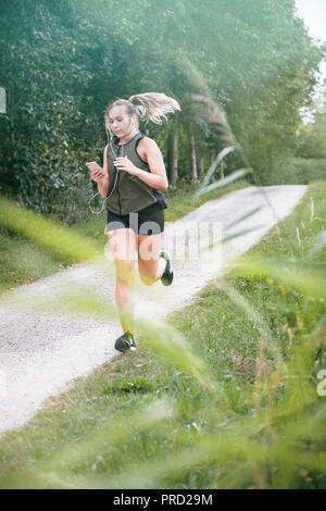 Blond sport Frau joggt in Park Stockfoto